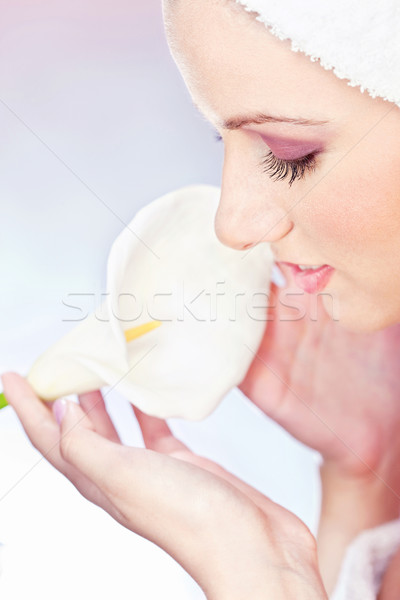 pretty woman with towel gently holding a white flower Stock photo © imarin