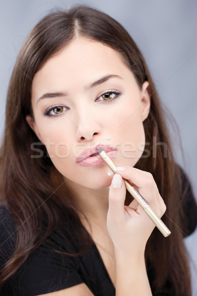 Stock photo: cosmetic pencil on woman's lips, focus on lips