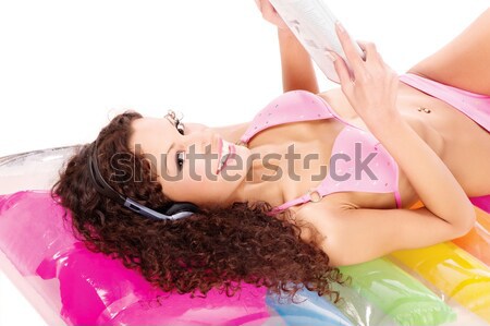 girl reading magazine on air mattress Stock photo © imarin