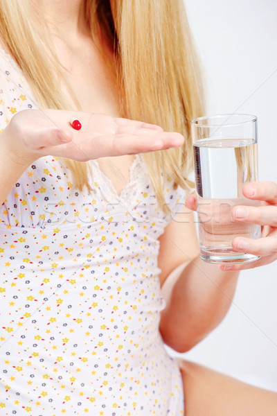 Red capsule in woman's hand Stock photo © imarin