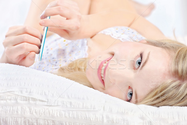 woman lying in bed and polishing nails Stock photo © imarin