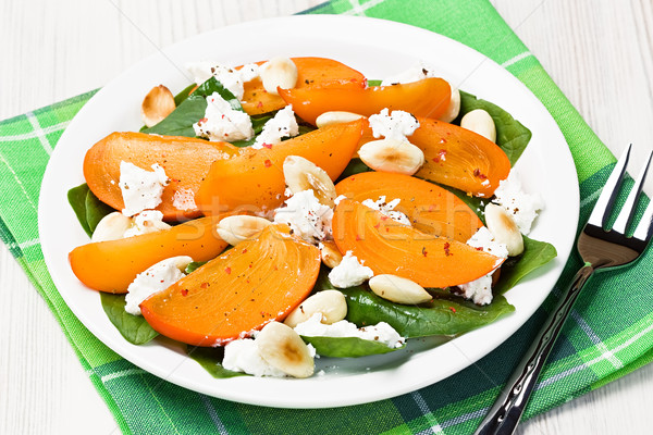 Spinach persimmon goat cheese salad with almonds Stock photo © IngridsI
