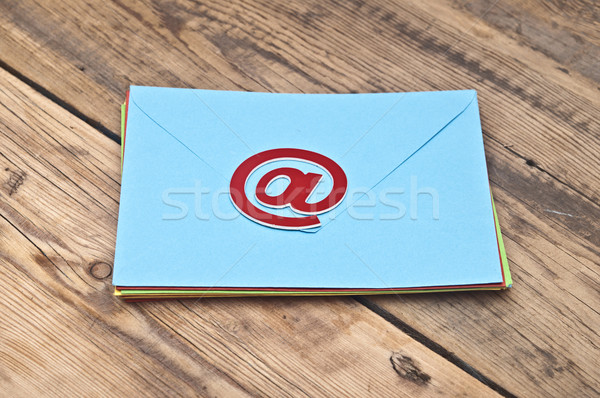 E-mail symbol and pile colorful envelopes on old wooden backgrou Stock photo © inxti