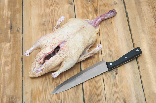 Raw duck and knife on wood background Stock photo © inxti