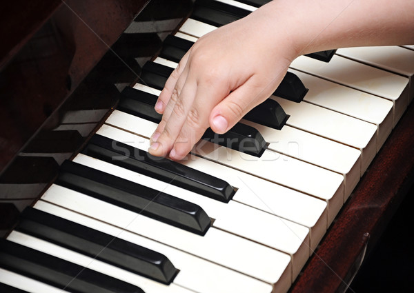 Child's hands playing a piano keyboard Stock photo © inxti