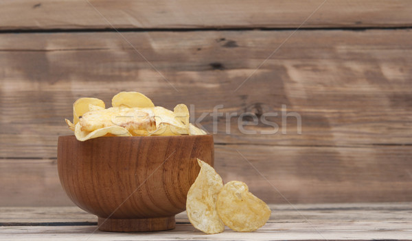 Cheese and chive potato crisp snack in brown bowl on wooden back Stock photo © inxti