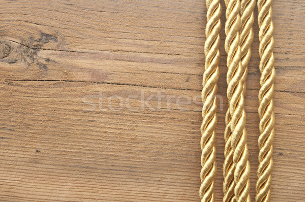 Twisted gold rope on wooden background  Stock photo © inxti