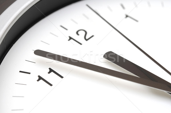 Hands pointing to midday on clock face  Stock photo © inxti