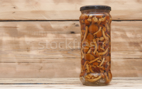 Mushrooms marinaded (agaric honey) in glass jar on wooden table Stock photo © inxti