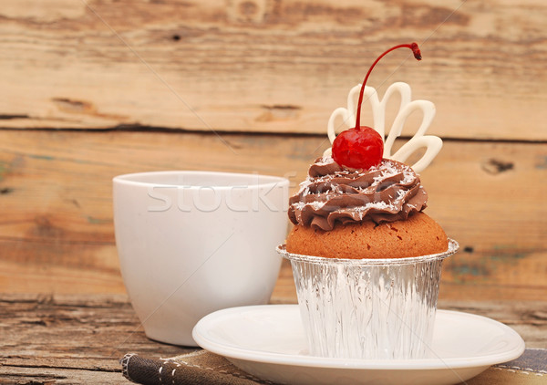 Cupcake with chocolate cream and cherry on old wooden background Stock photo © inxti