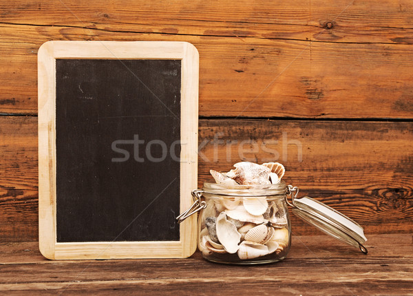 Seashells in a jar on wooden background  Stock photo © inxti