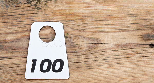 label with room number 100 on wood table Stock photo © inxti