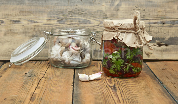 Sun dried tomatoes with olive oil and fresh garlic in glass jar  Stock photo © inxti