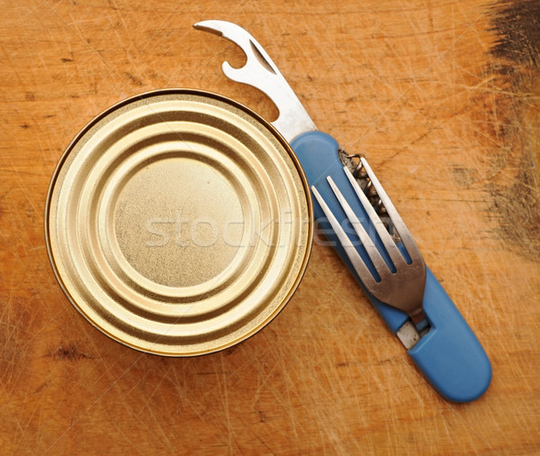 The old tin opener opening a can on wooden table Stock photo © inxti