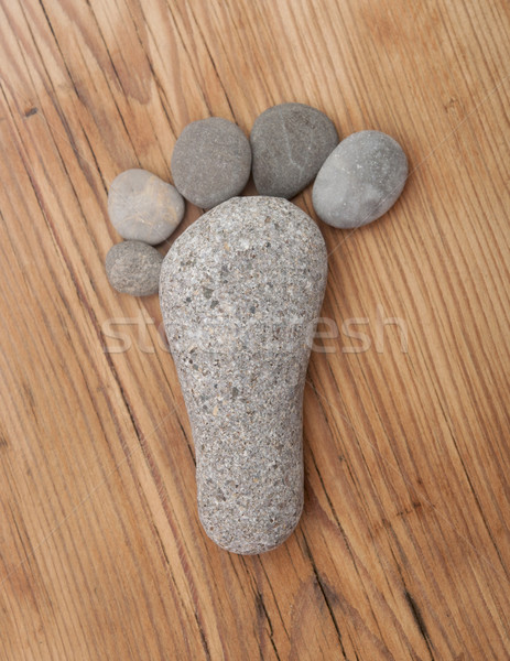 A group of stones is arranged as a footprint on a wood texture b Stock photo © inxti