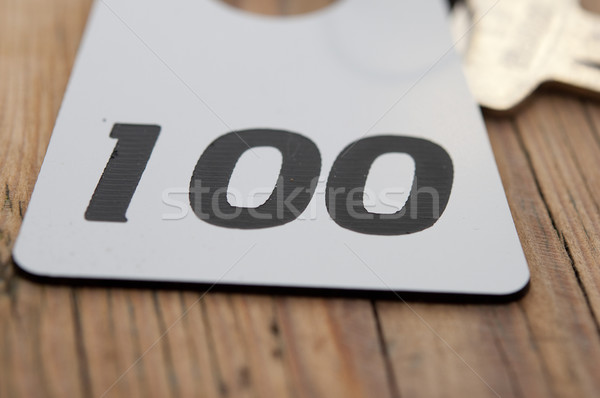 Hotel suite key with room number 100 on wood table  Stock photo © inxti