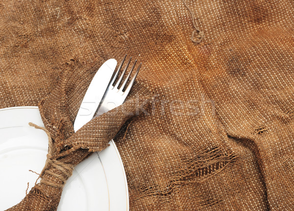 A place setting with silver fork and knife on old sacking textur Stock photo © inxti