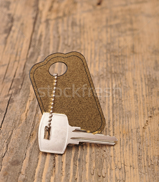 Stock photo: silver key with blank tag wooden background. space for your text