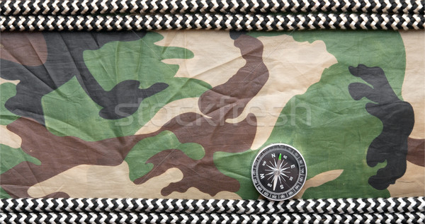 Compass and rope on a camouflage background Stock photo © inxti