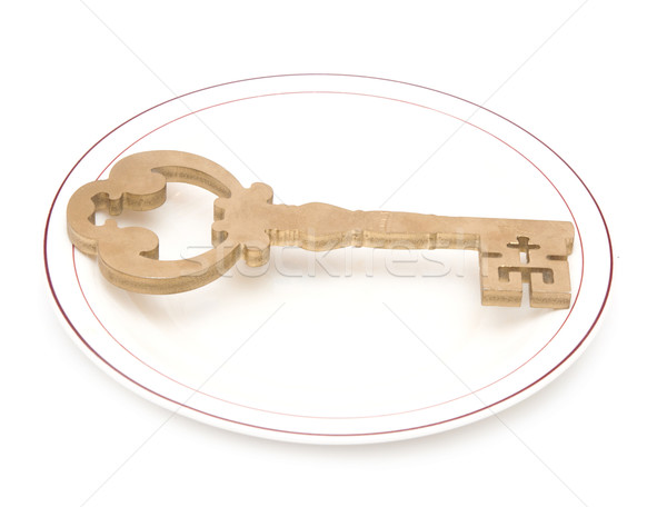 Big vintage key on white china plate with golden edging isolated Stock photo © inxti