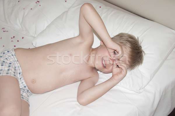Adorable funny sleepy blond boy lying in a bed  Stock photo © inxti