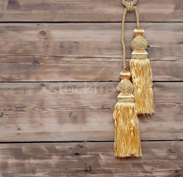 Gold rope with curtain tassel against wooden wall Stock photo © inxti
