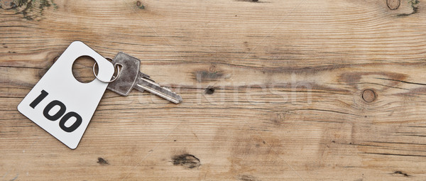 Hotel suite key with room number 100 on wood table  Stock photo © inxti