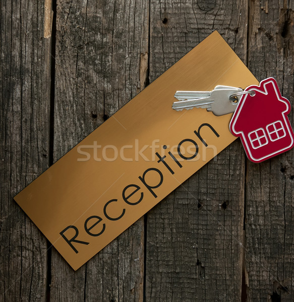 Symbol of the house with silver key on wooden reception desk  Stock photo © inxti