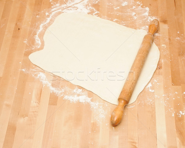 Classic wooden rolling pin with freshly prepared dough and dusti Stock photo © inxti
