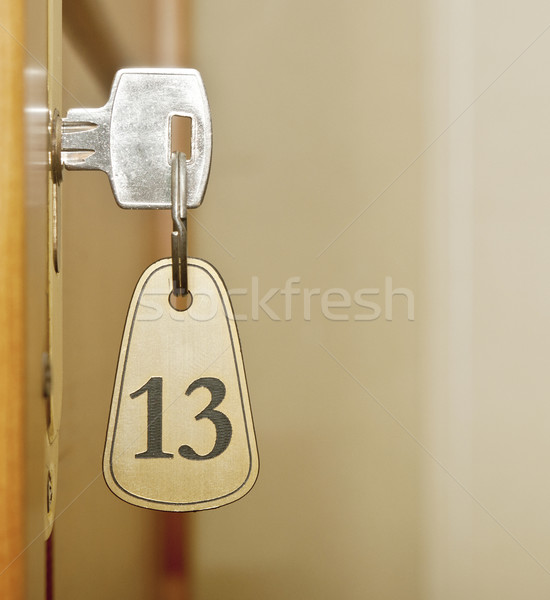 Closeup of an old keyhole of room number 13 with key on a wooden Stock photo © inxti