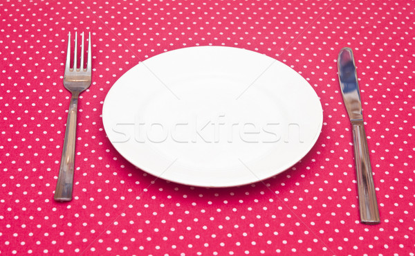 Empty white dinner plate with utensils on fun red polka dot tabl Stock photo © inxti