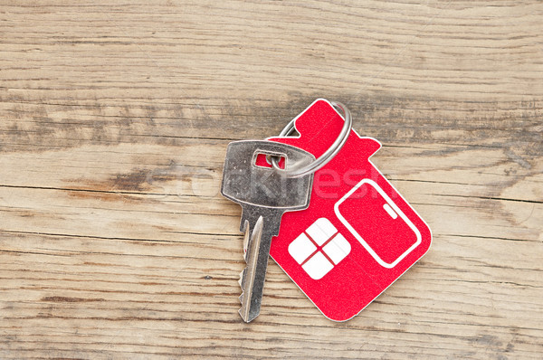 Stock photo: A key in a lock with house icon on it 