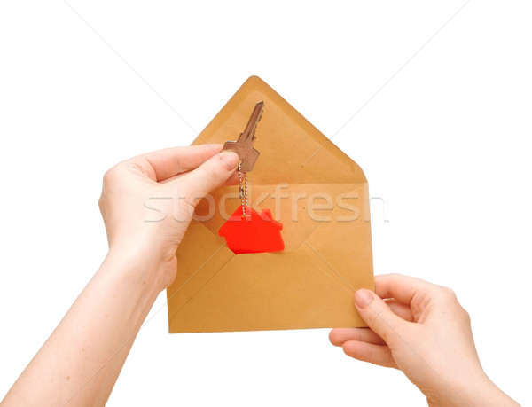 a woman's hand gets out of an envelope key with house symbol Stock photo © inxti