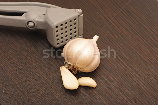 Garlic press with crushed bulb.  Stock photo © inxti
