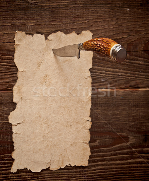 Stock photo: Old paper pinned to a wooden wall with a knife