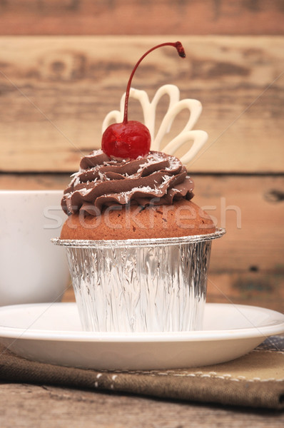 Cupcake with chocolate cream and cherry on old wooden background Stock photo © inxti