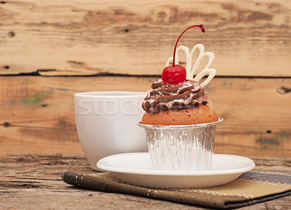 Cupcake with chocolate cream and cherry on old wooden background Stock photo © inxti