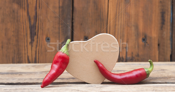 red chilly peppers with cardboard heart on wood background Stock photo © inxti
