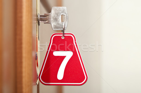 Door wood and key in keyhole with numbered label  Stock photo © inxti