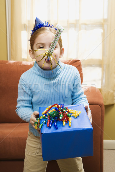 Girl blowing noisemaker. Stock photo © iofoto