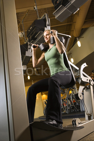 Woman using exercise equipment. Stock photo © iofoto