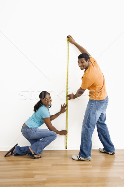 Stock photo: Couple measuring wall.