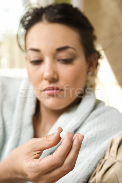 Woman holding pill. Stock photo © iofoto