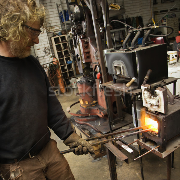 Metalsmith heating metal in forge. Stock photo © iofoto