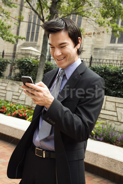 Empresário sorridente celular mensagem asiático homem de negócios Foto stock © iofoto