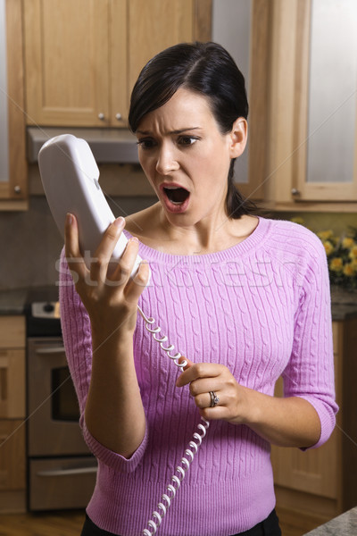Woman Holding Phone in Disbelief Stock photo © iofoto