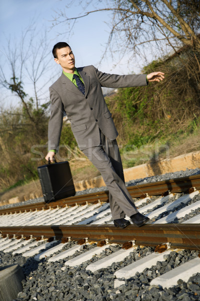 Businessman Walking on Railroad Tracks Stock photo © iofoto