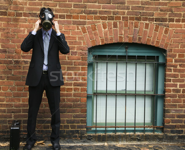 Imprenditore indossare maschera antigas piedi muro di mattoni uomo Foto d'archivio © iofoto