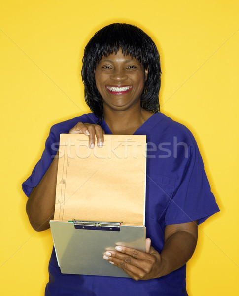 Nő orvosi egyenruha olvas diagram mosolyog Stock fotó © iofoto