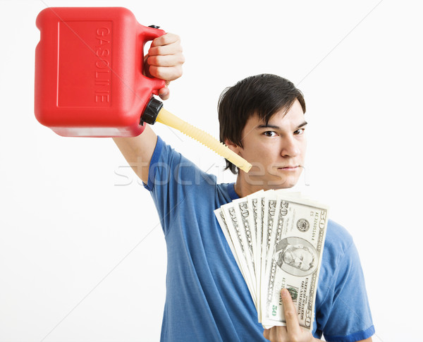 Man pouring gas on money. Stock photo © iofoto